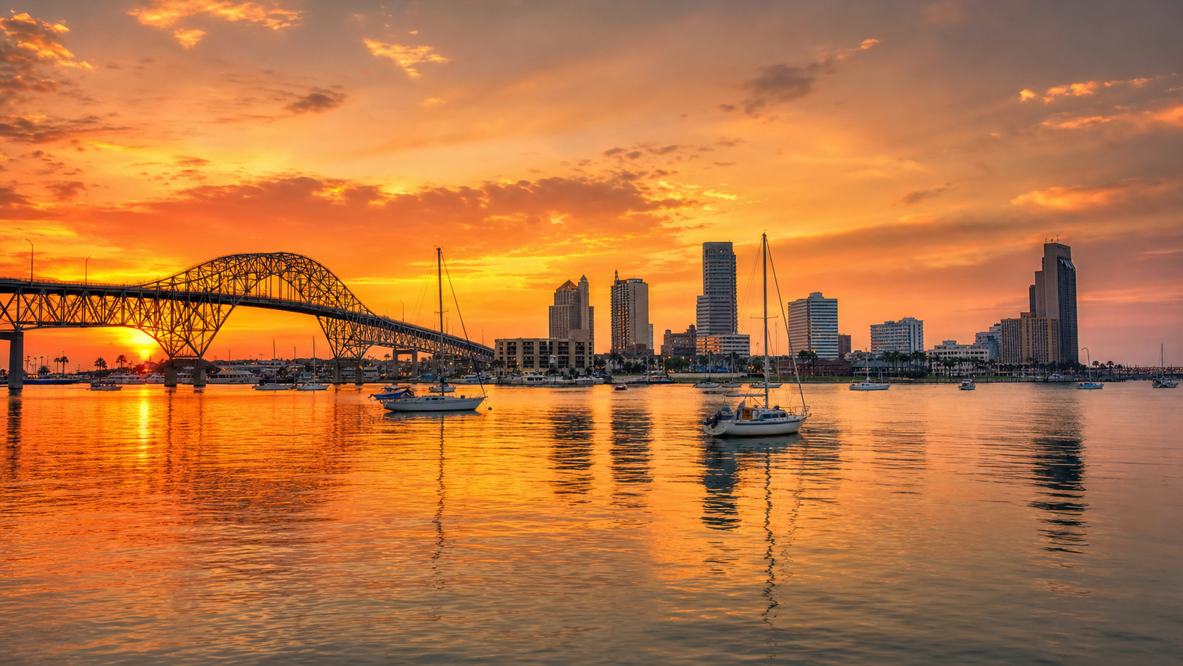 Corpus Christi Texas Bay skyline at sunset with Harbor Bridge and sailboats
